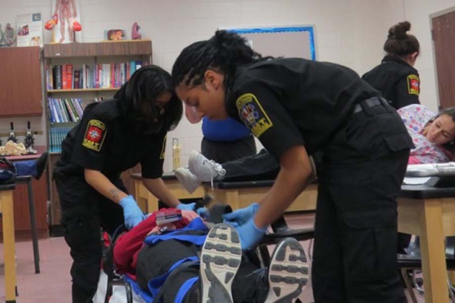 Two Atlantic County students train using a gurney as part of EMT practice.