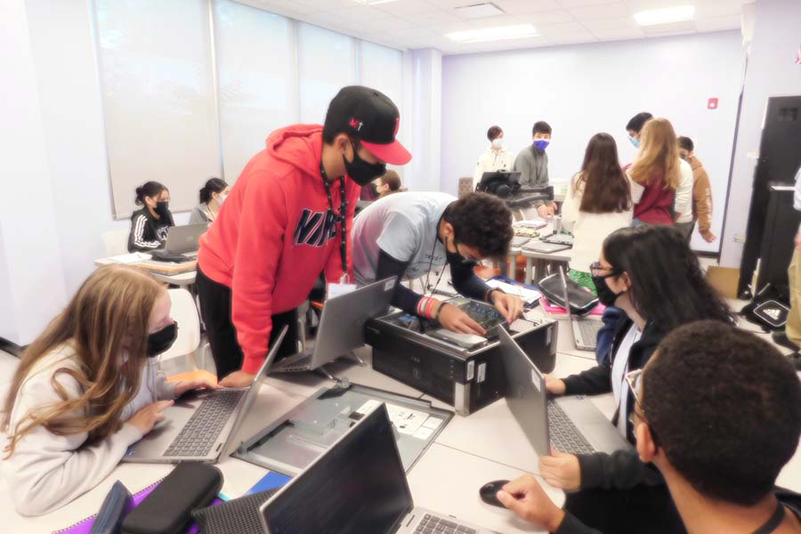 Bergen cybersecurity students work to dissect a computer.