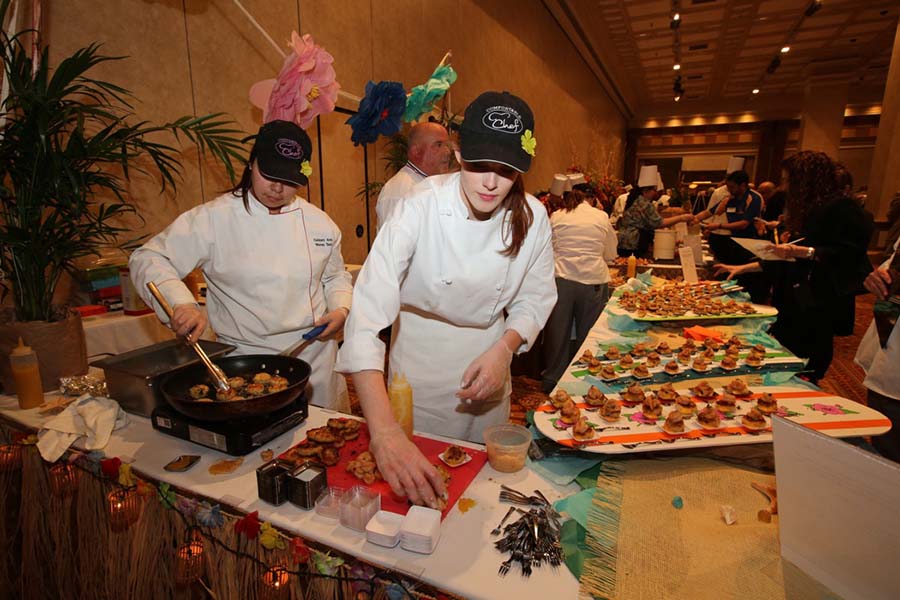Two BCIT culinary students prepare food for a cook-off with an island theme.