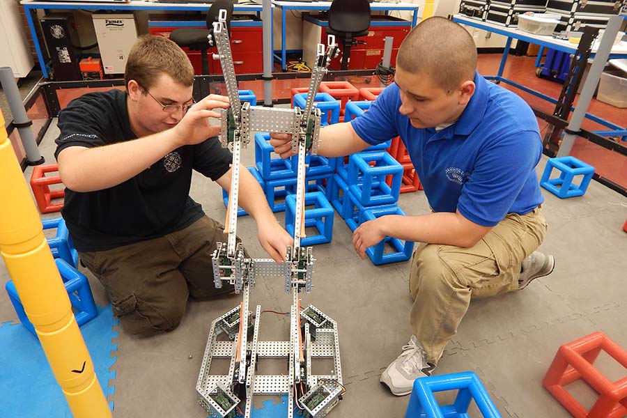 Burlington County engineering students assemble a project on the floor.