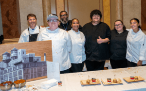 Chef David Burke chose the Camden County Technical Schools team as the Gold Medal winner in both the Taste and Presentation categories. He was inspired by the team's mini Campbell Soup cans used to serve a delicious Smoked Corn & Lobster Chowder alongside a mini cheesesteak. The winning team is pictured with their instructors smiling.
