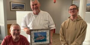 Chef Rob Ohlsen, center, poses with Dr. John R. Burns, far left, who is a retired Cumberland County Techncial Education Center assistant principal. They are pictured with an attendee of the 2023 Thanksgiving feast at the US Coast Guard Base in Cape May.