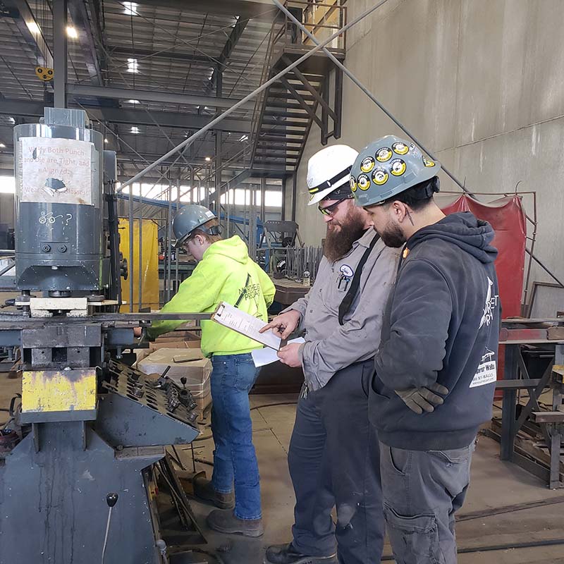 An employer partner from Northeast Precast works at their business, on the job, with a student from Cumberland County.