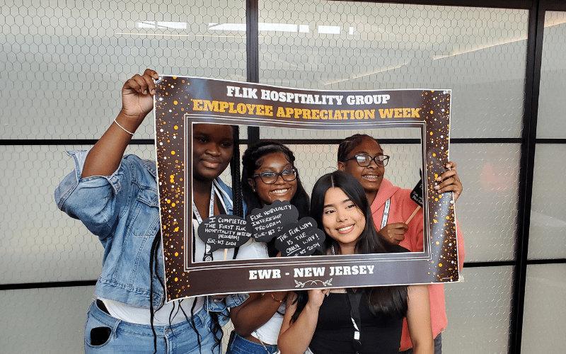 Essex County Schools of Technology students pose in a photo frame on the job with Flik Hospitality