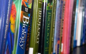 Science books stacked on a shelf