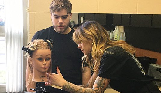 A Mercer county cosmetology student practices on a mannequin
