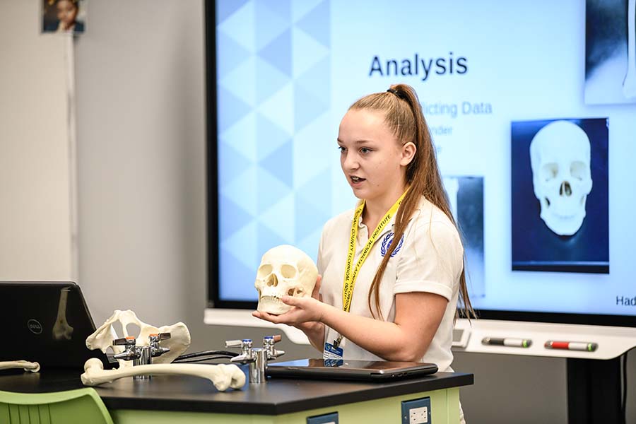A Passaic County student gives a presentation using a skull replica.
