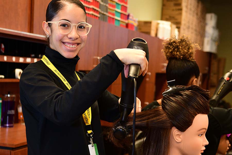 A Passaic County student gets hands-on cosmetology experience on a mannequin.