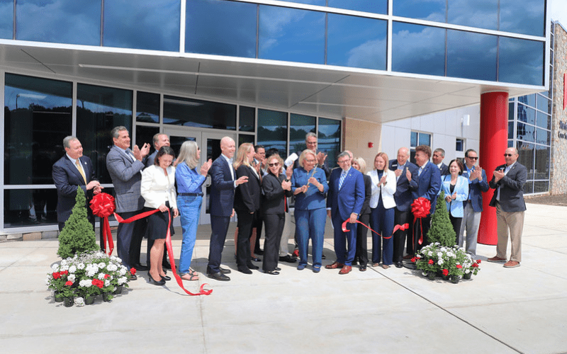 A line of school officials and dignitaries cutting ribbon for the morris career center