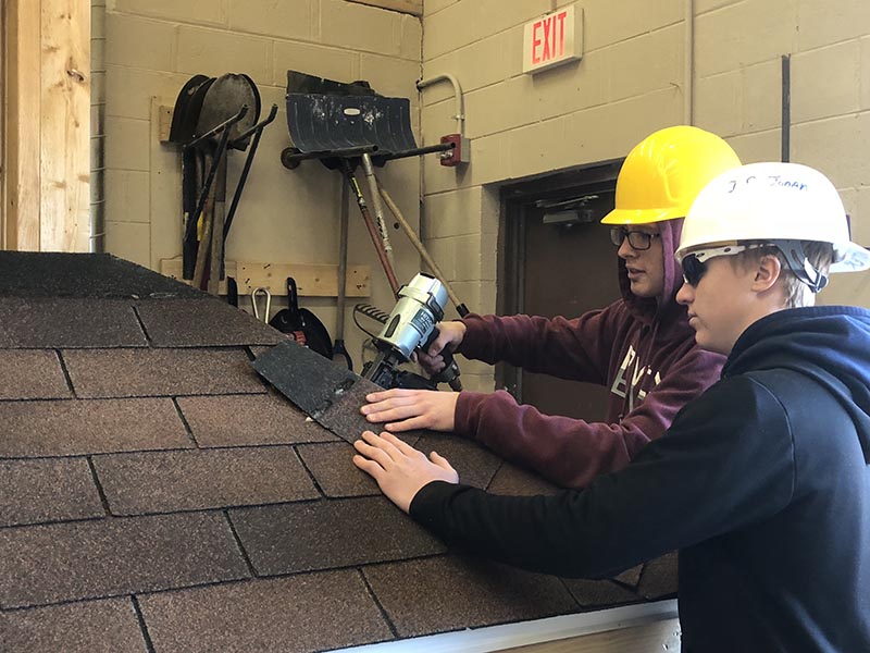 Salem students gain hands-on experience attaching a roof.