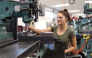 Female Student working with heavy machinery