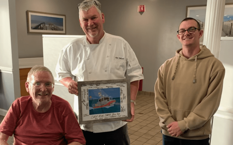 Chef Rob Ohlsen, center, poses with Dr. John R. Burns, far left, who is a retired Cumberland County Techncial Education Center assistant principal. They are pictured with an attendee of the 2023 Thanksgiving feast at the US Coast Guard Base in Cape May.