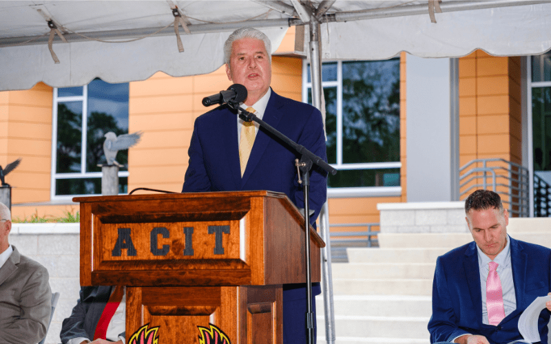 Superintendent of ACIT standing at podium giving speech