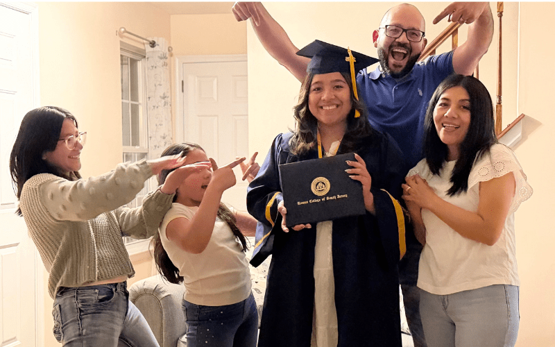 Graduate holding diploma in cape and gown